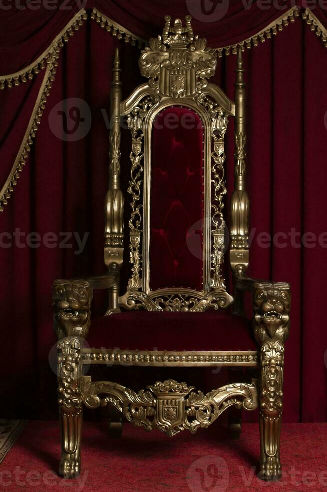 Red royal chair on a background of red curtains. Place for the king. Throne photo