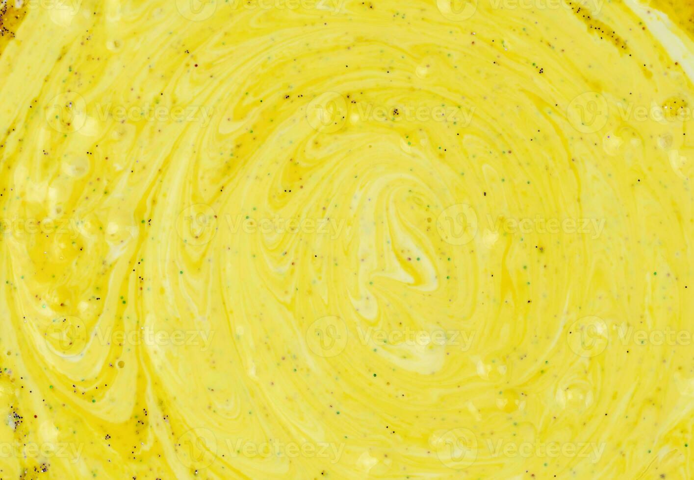 Yellow background of liquid marble sprinkled with sparkles. photo