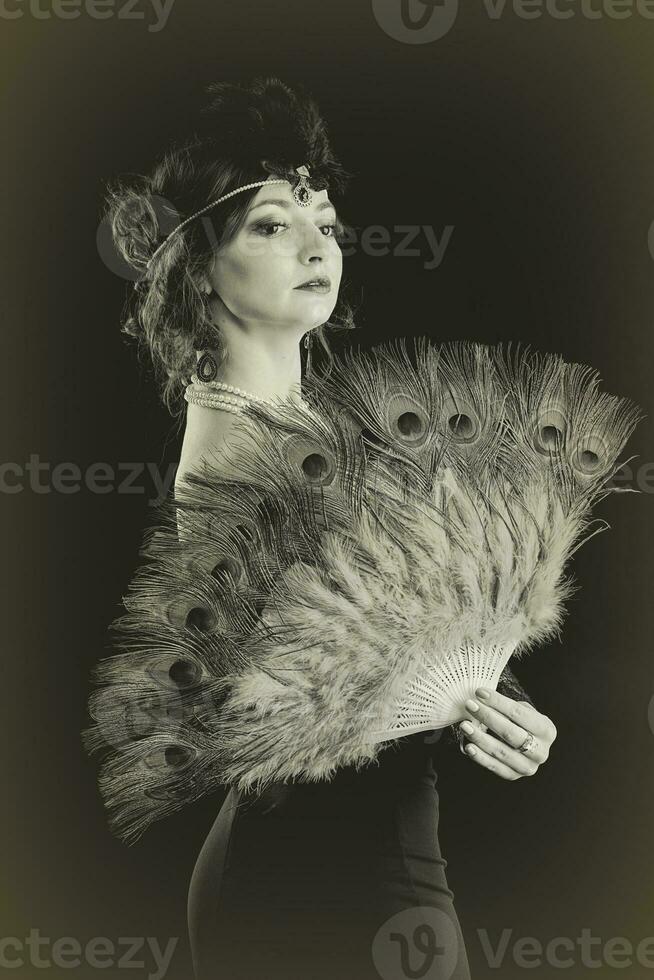 Retro black and white female portrait with fan in 20s or 30s style. photo