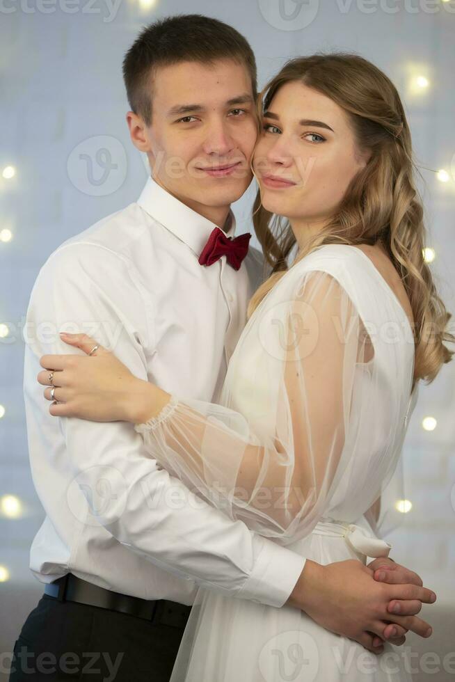 en un gris fondo, el novia y novio Mira a cada otro. hermosa Pareja en amor. foto