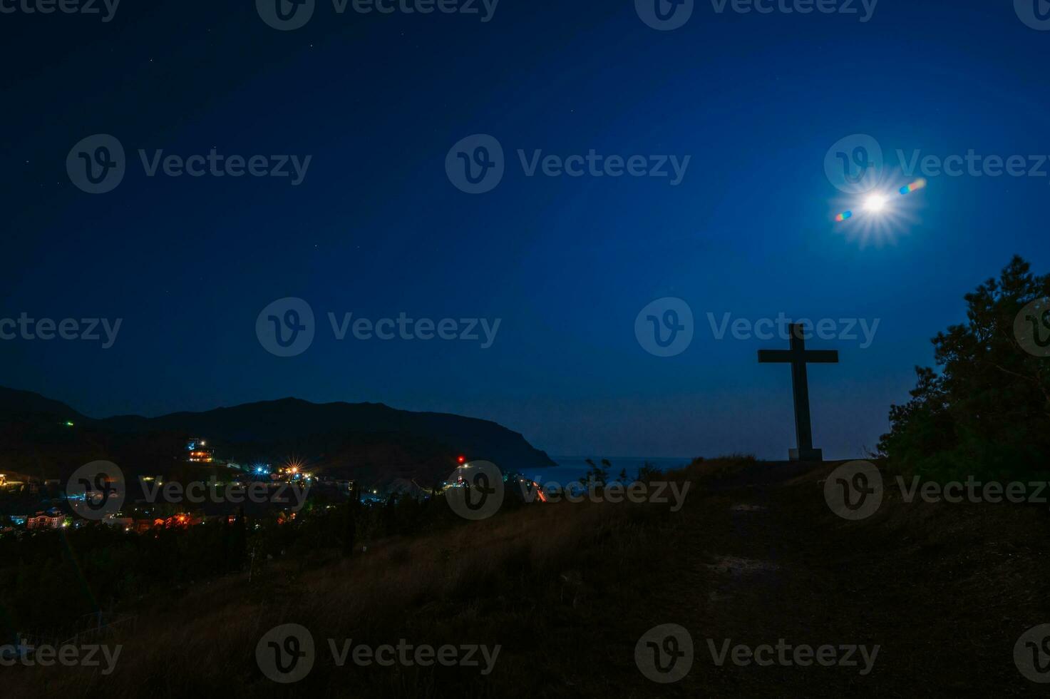 Evening landscape. The Cross of God on a hill overlooking the outskirts of the city and the sea. A small town in the Crimea. Marine. photo