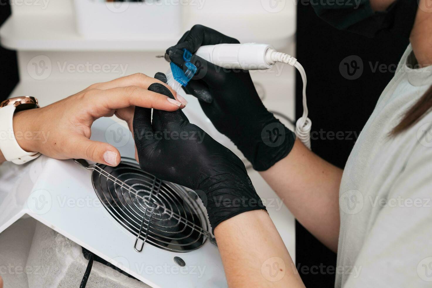 Close-up of the manicure master sawing the surface of the nail with a cutter on an electric machine. The concept of salon professional manicure photo