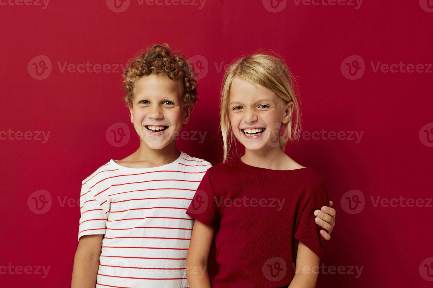 two joyful children emotions stand side by side in everyday clothes isolated background photo