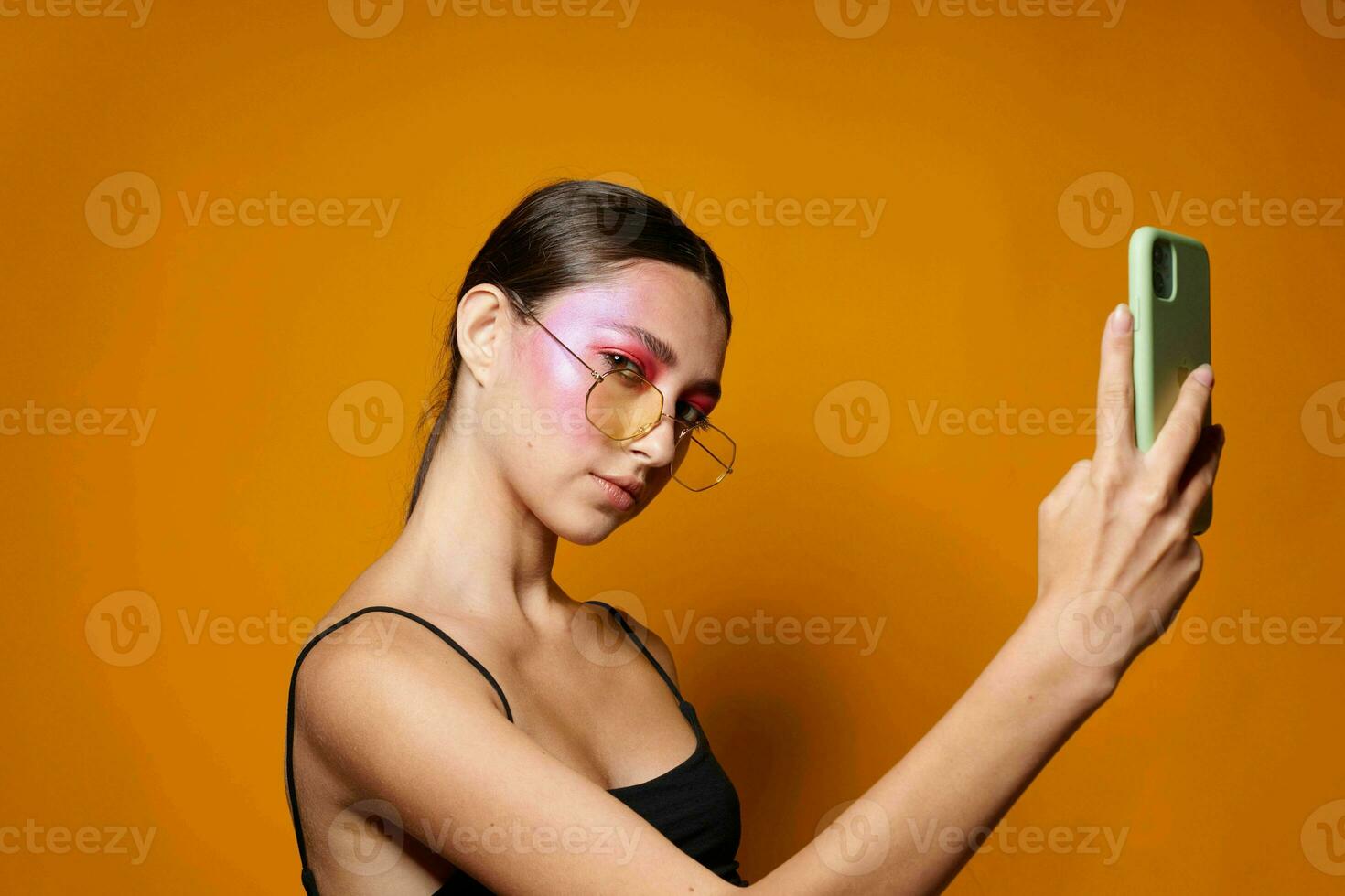 Beauty fashion female with glasses bright makeup posing black jersey talking on the phone cropped view unaltered photo