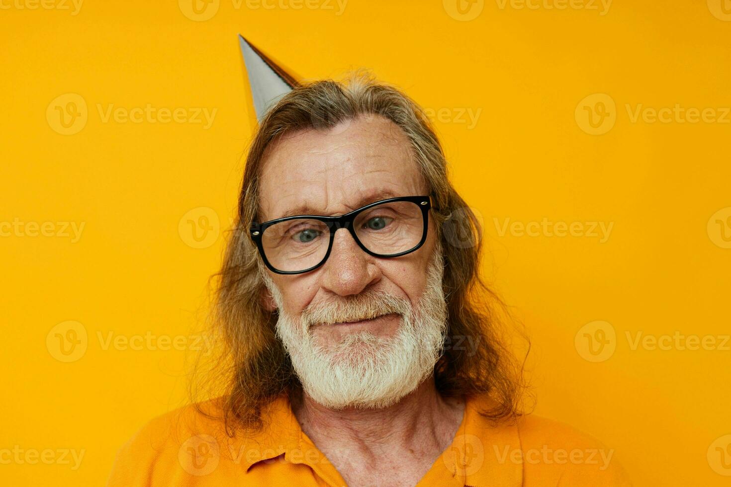 cheerful elderly man in glasses with a cap on his head yellow background photo