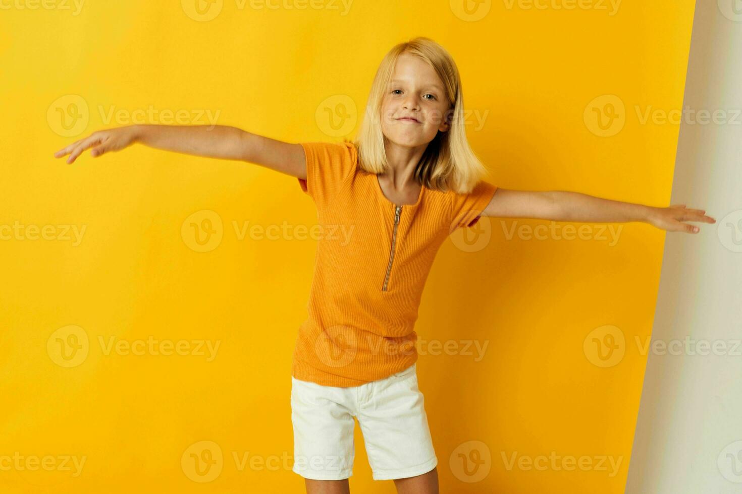 Little girl smile hand gestures posing casual wear fun yellow background unaltered photo