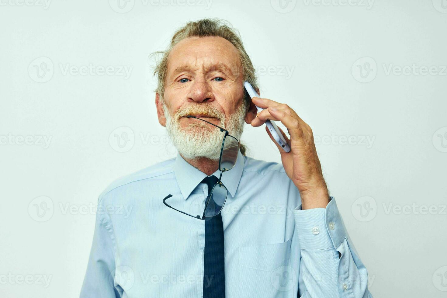 Portrait of happy senior man in a shirt with a tie with a phone technology cropped view photo