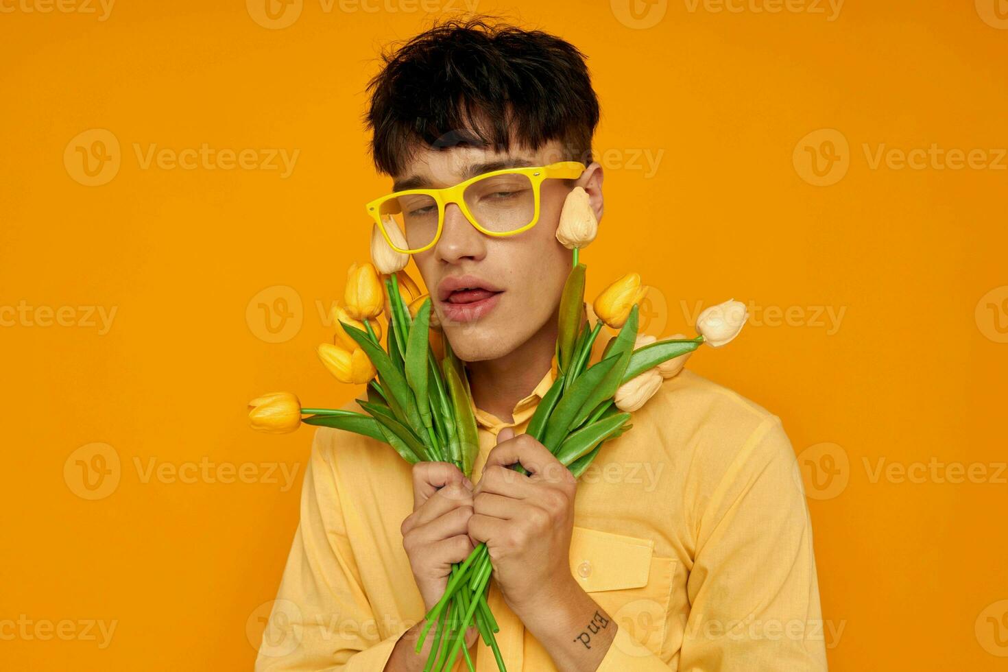 handsome guy with a bouquet of flowers posing a gift isolated background unaltered photo