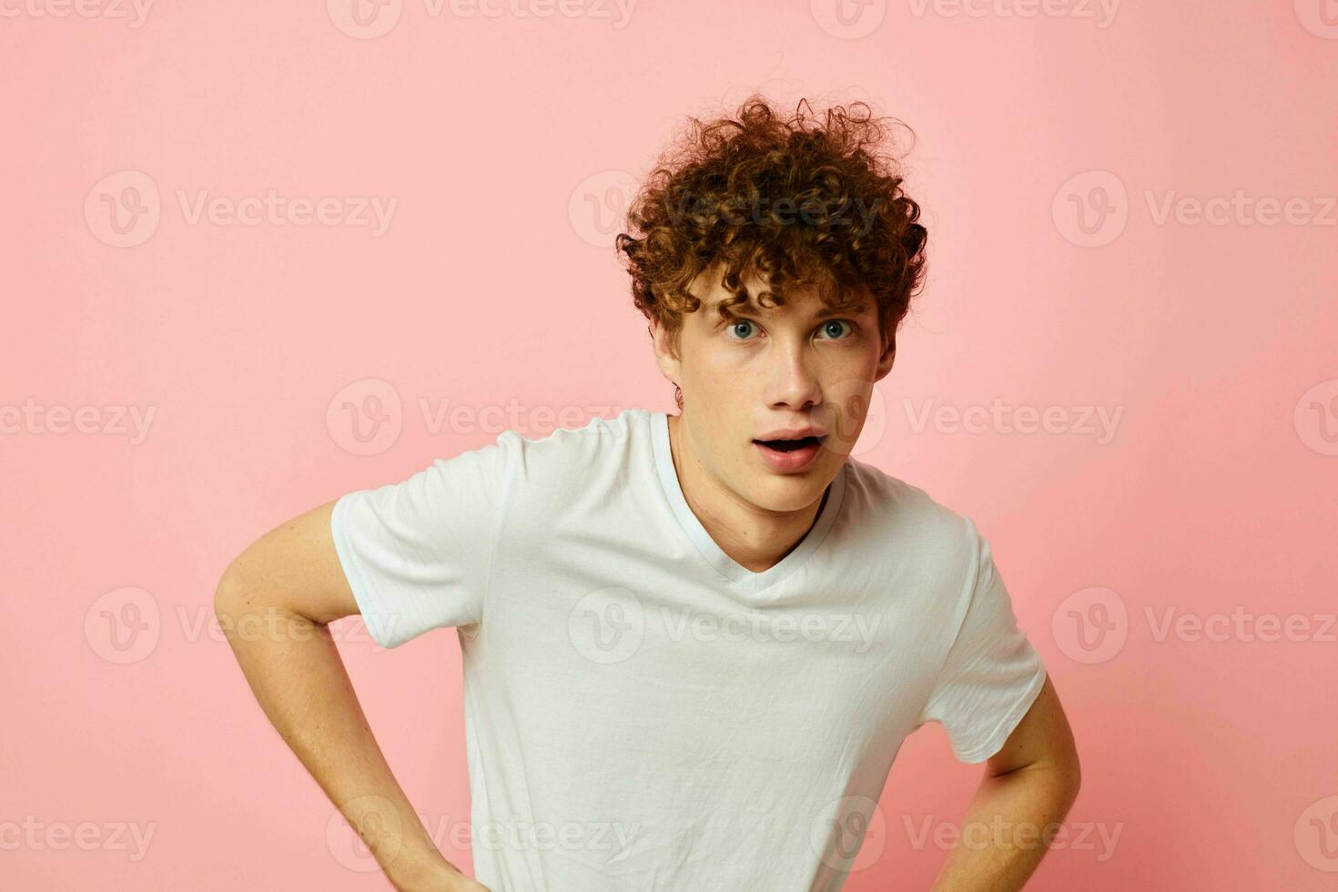 joven pelo rizado hombre posando juventud estilo blanco camiseta rosado antecedentes inalterado foto