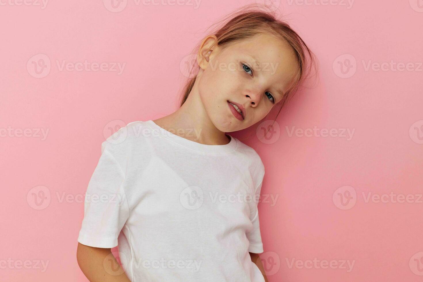 retrato de contento sonriente niño niña en un blanco camiseta sonrisa rosado antecedentes foto