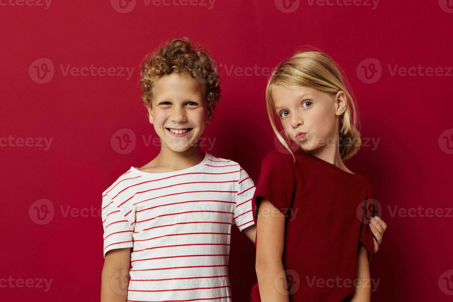 Boy and girl smiling and posing in casual clothes against on colored background photo