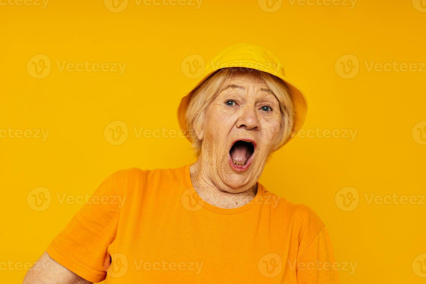 elderly woman in yellow t-shirts hat posing isolated background photo