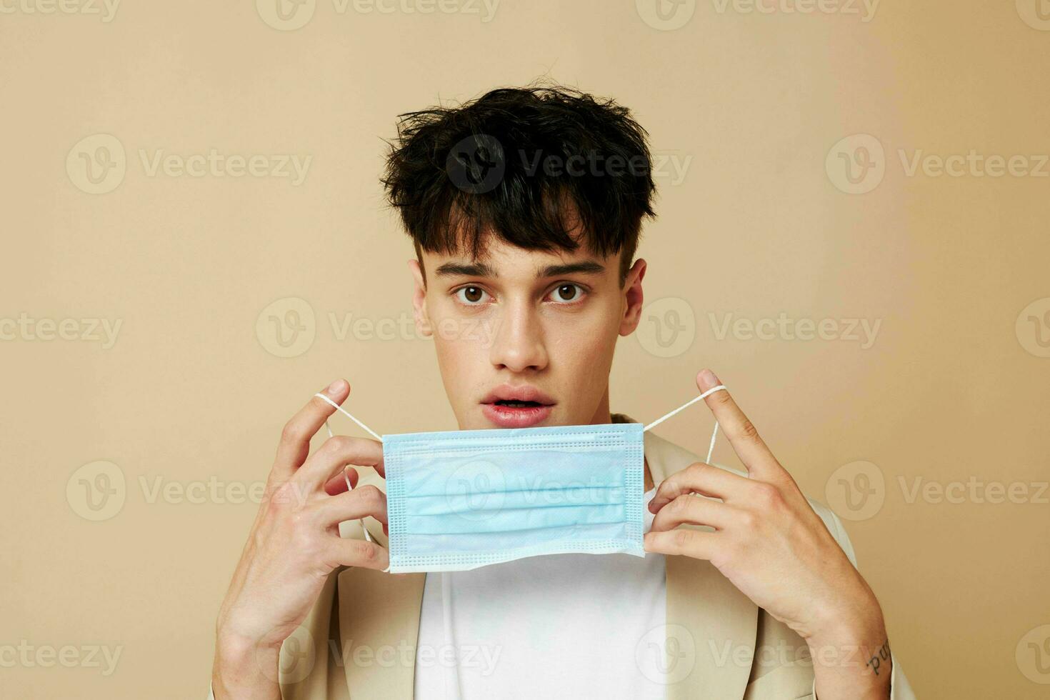 portrait of a young man a man in a light jacket medical mask isolated background unaltered photo