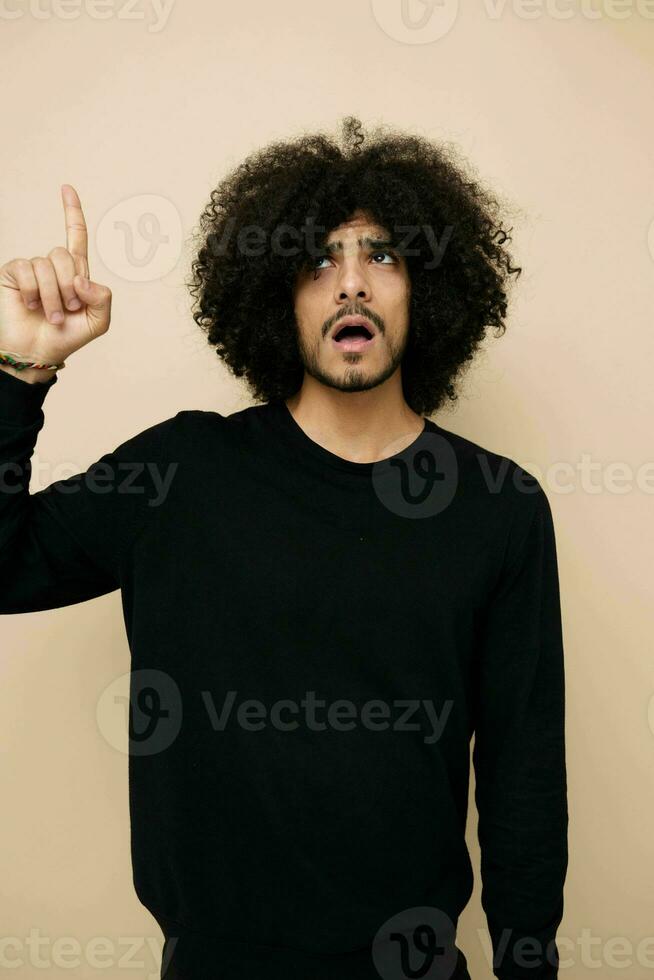 man with curly hair in a black sweater hand gesture isolated background photo