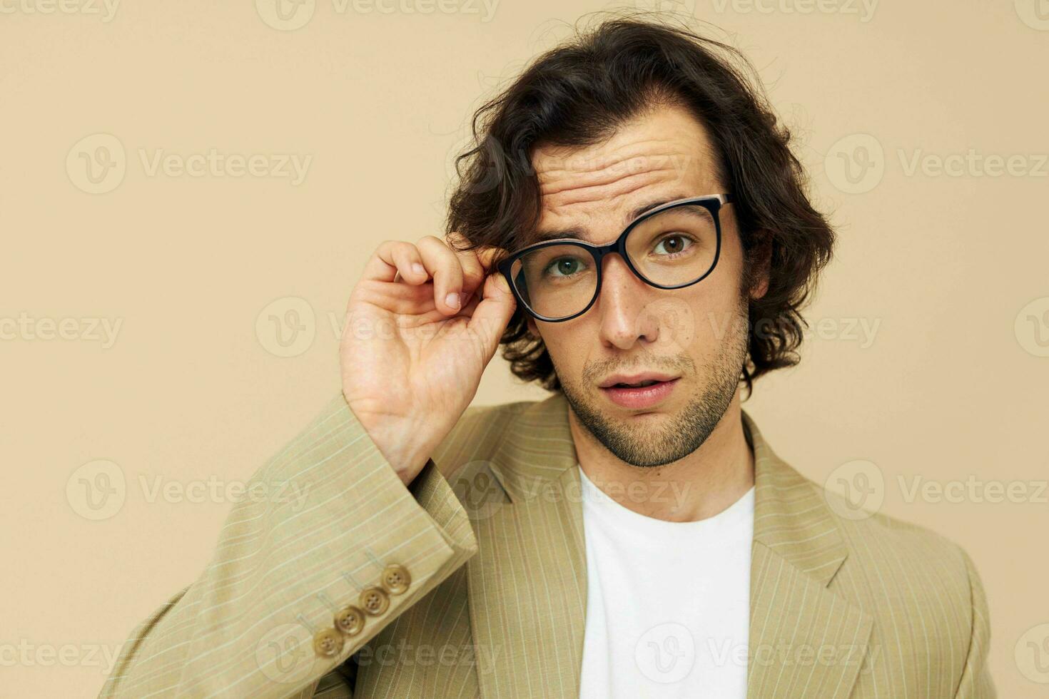 Cheerful man in a suit posing emotions wear glasses beige background photo
