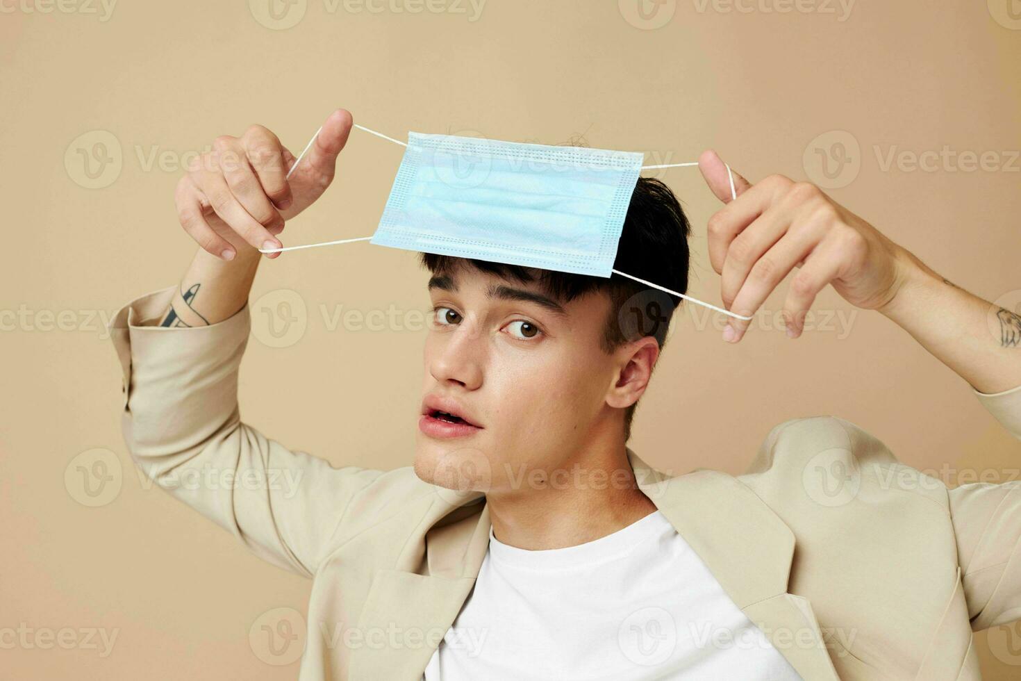 portrait of a young man in a medical mask in the hands of posing fashion isolated background unaltered photo