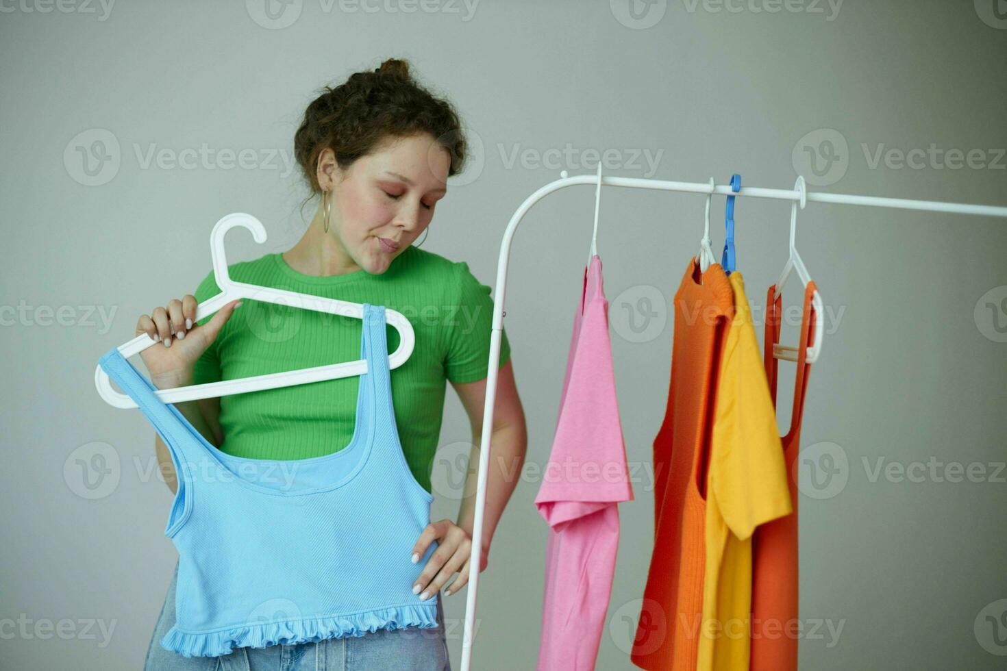 cheerful woman trying on clothes wardrobe Youth style light background unaltered photo