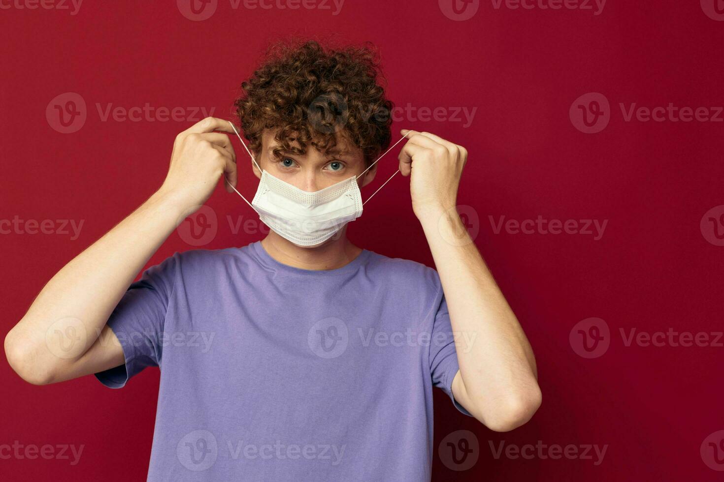 young guy medical mask protection posing red background unaltered photo