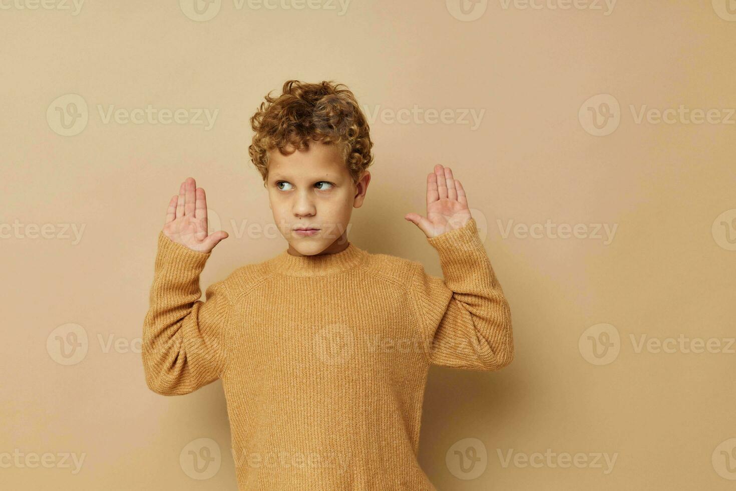 Cute little boy in a beige sweater posing fun childhood unaltered photo