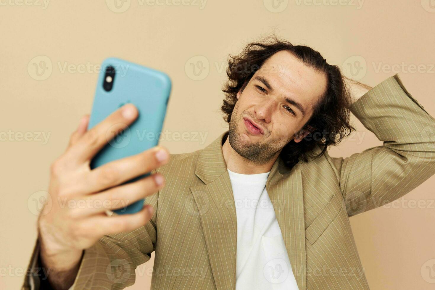 Cheerful man in a suit posing emotions looking at the phone isolated background photo
