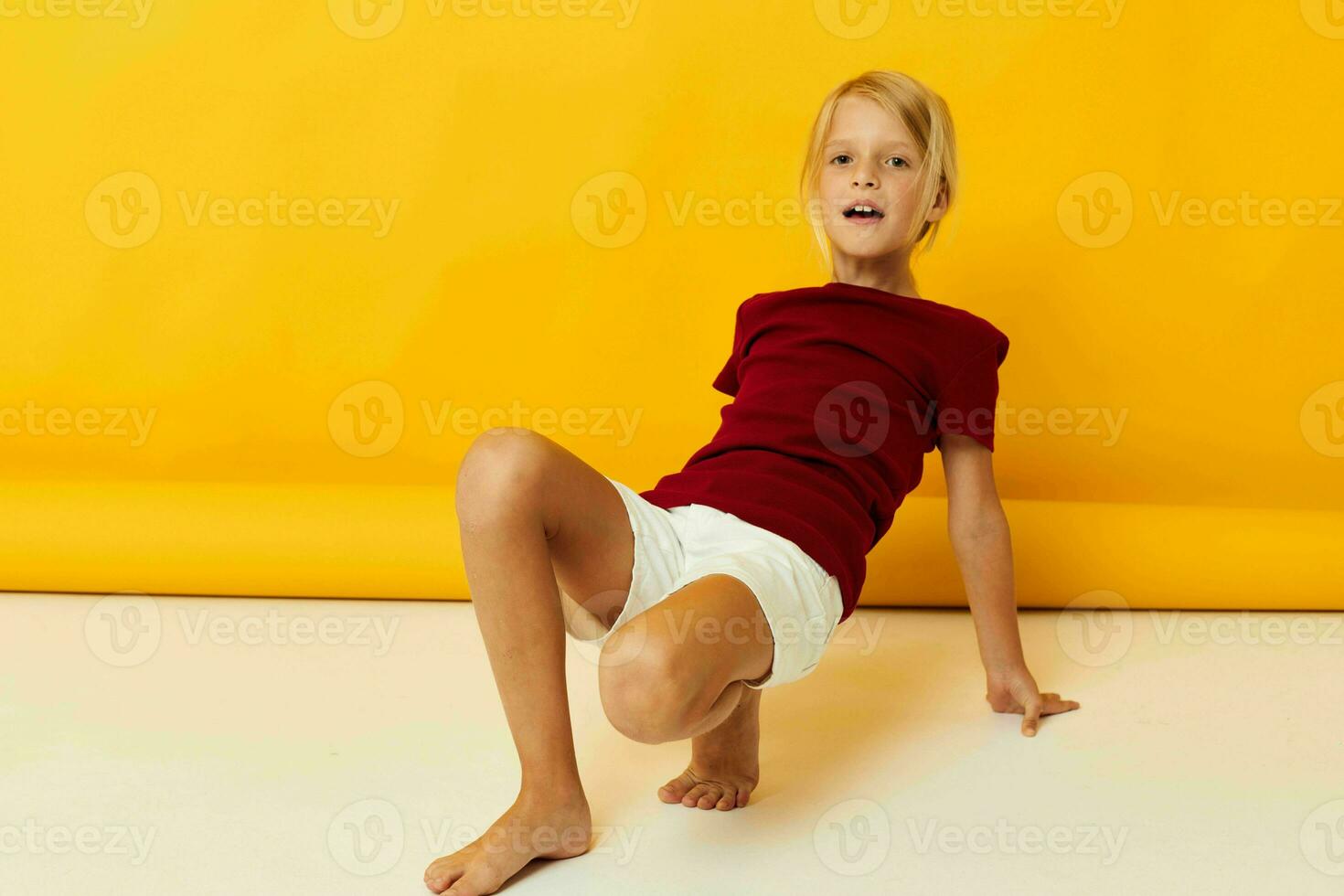 little girl sitting on the floor posing in casual clothes photo
