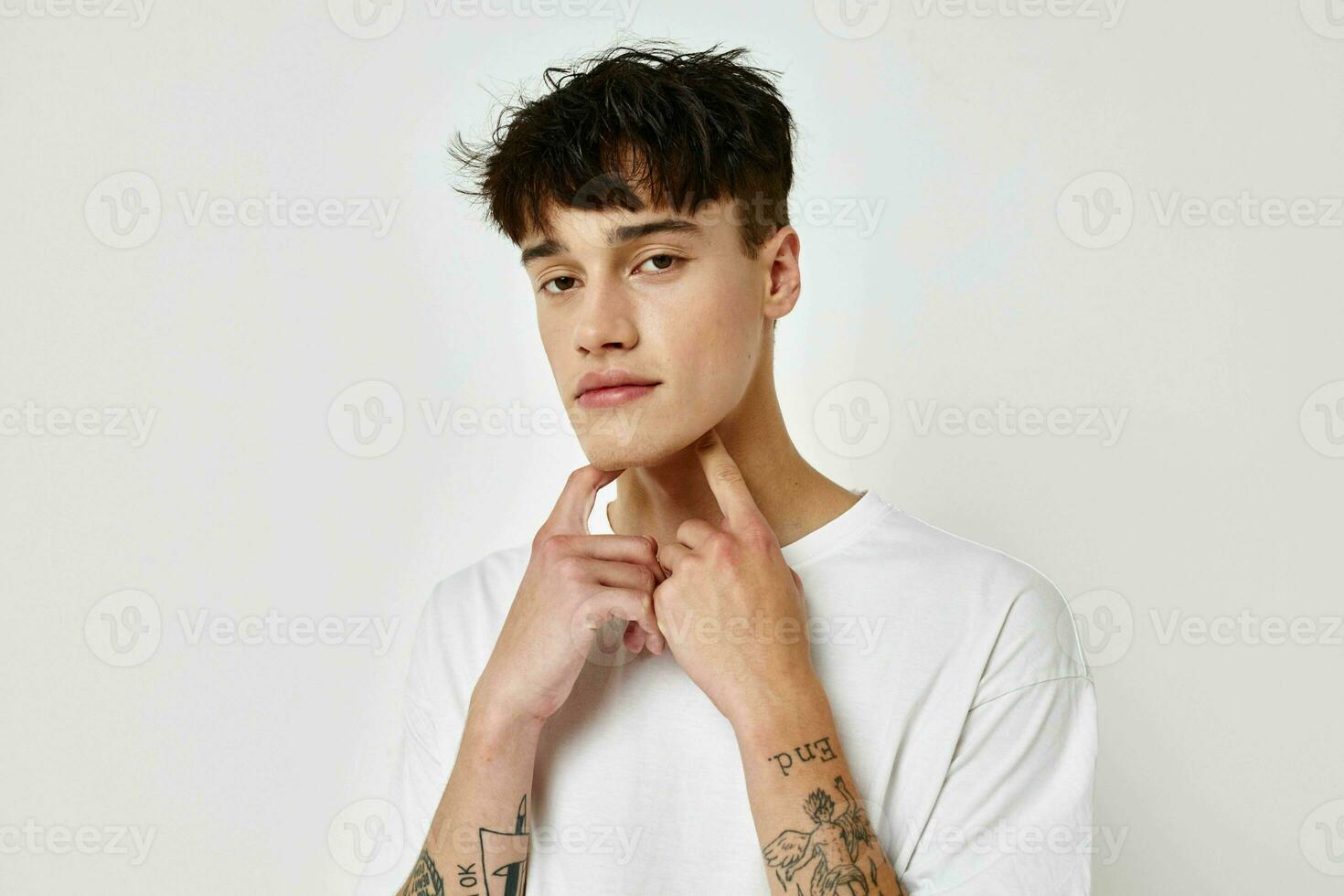 handsome guy modern youth style white t-shirt tattoo on the arm model studio photo