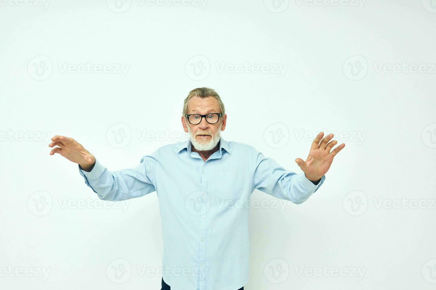 Photo of retired old man in blue shirts gestures with his hands cropped view