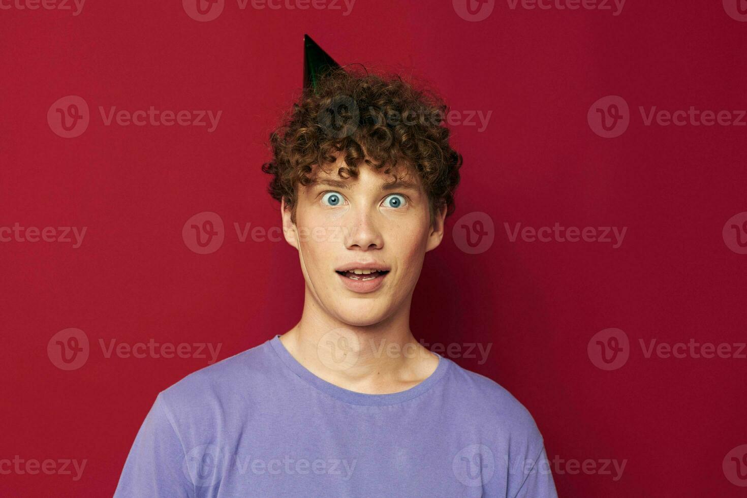 cute guy with a cap on his head emotions close-up red background photo