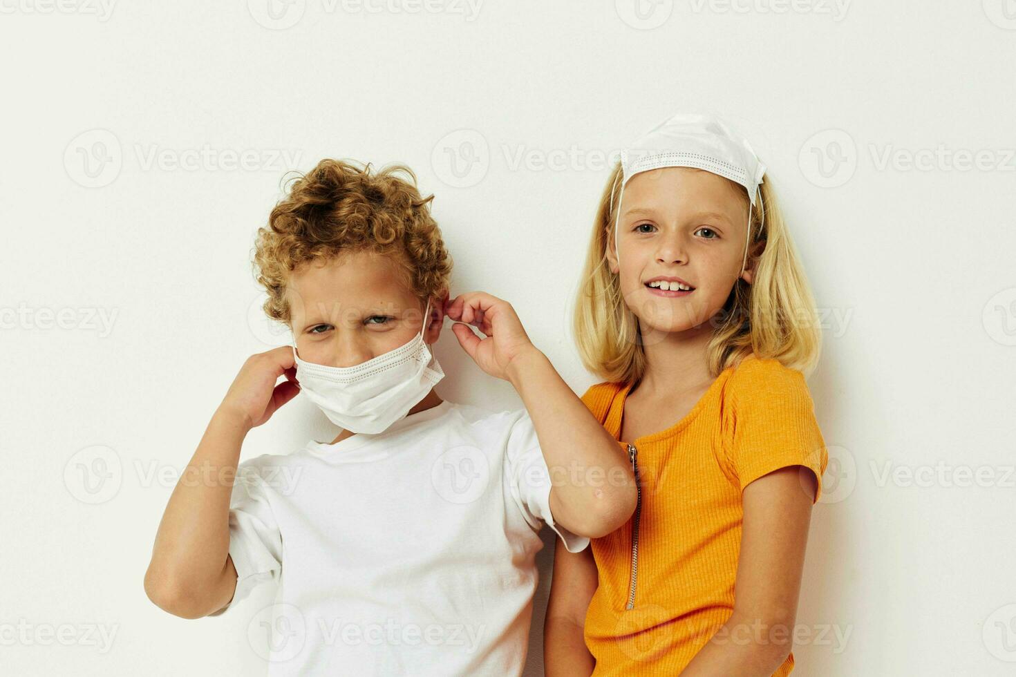 Portrait of cute children in medical mask protection posing grimace light background photo