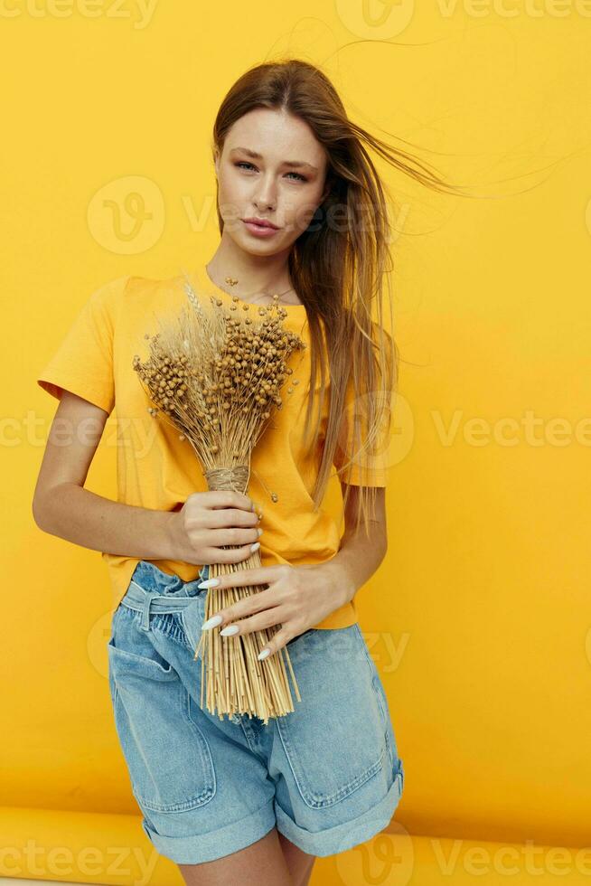 beautiful woman wearing a hat dry flowers summer style yellow background photo