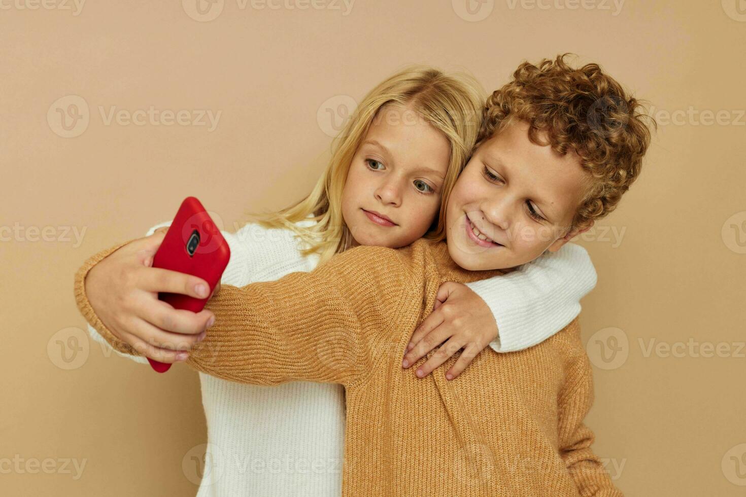 Little boy and girl with a red phone together technologies isolated background photo