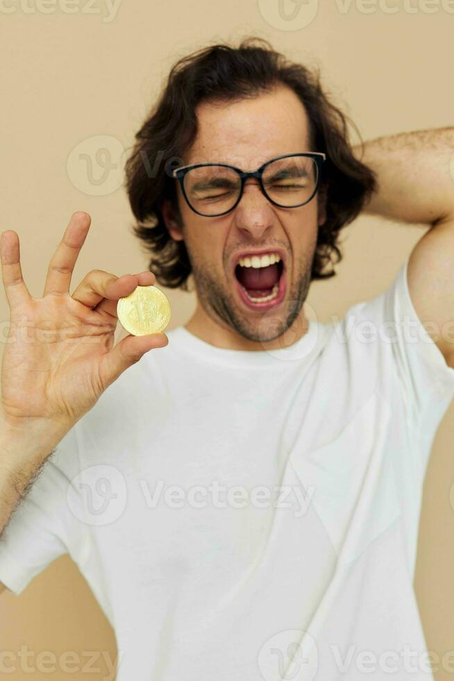 handsome man with glasses gold bitcoin in hands isolated background photo