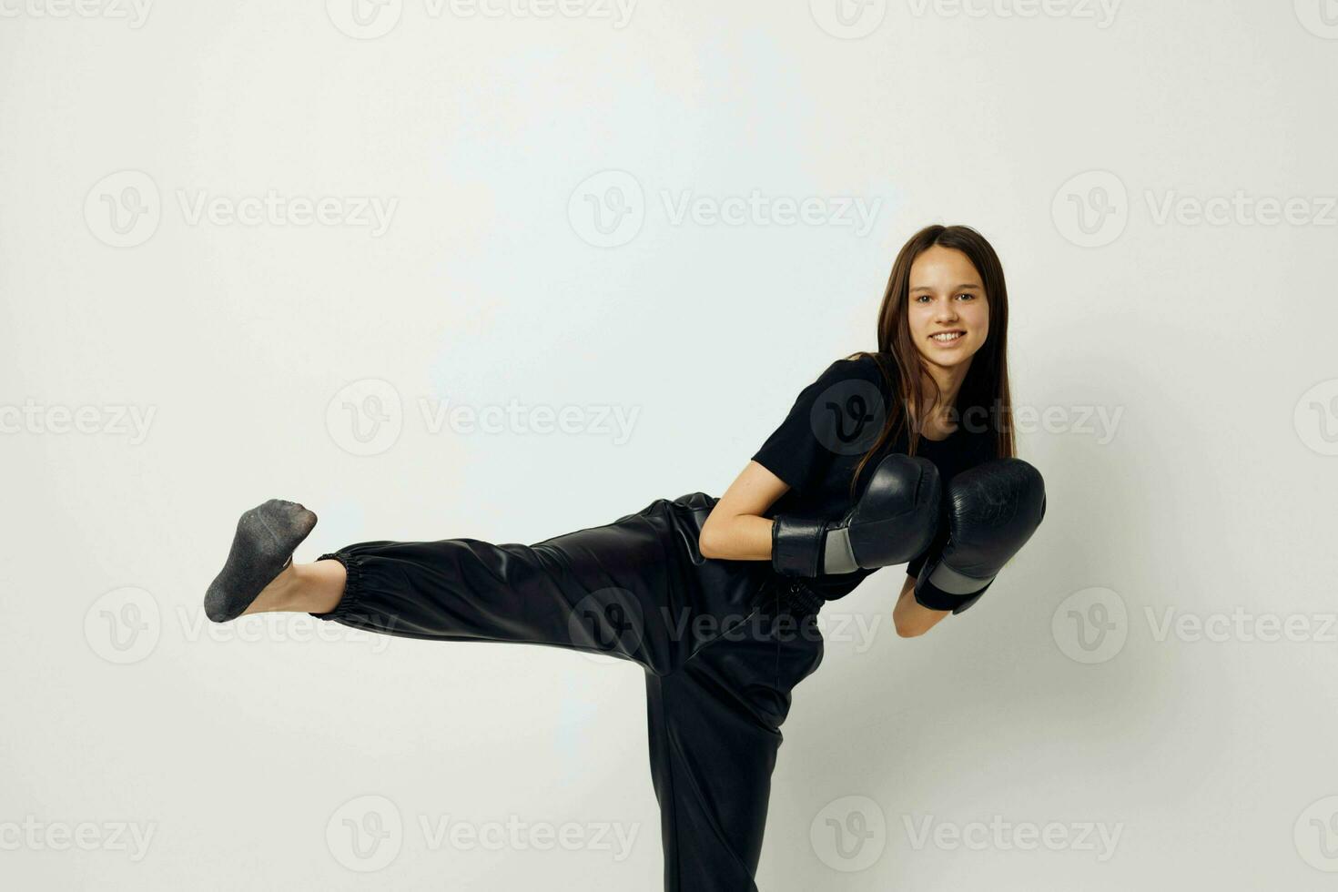 young woman in boxing gloves punch in black pants and a T-shirt isolated background photo