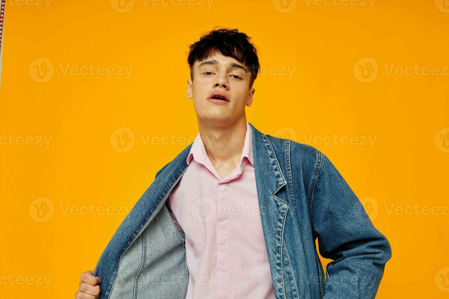 handsome man in denim jacket youth style posing yellow background photo