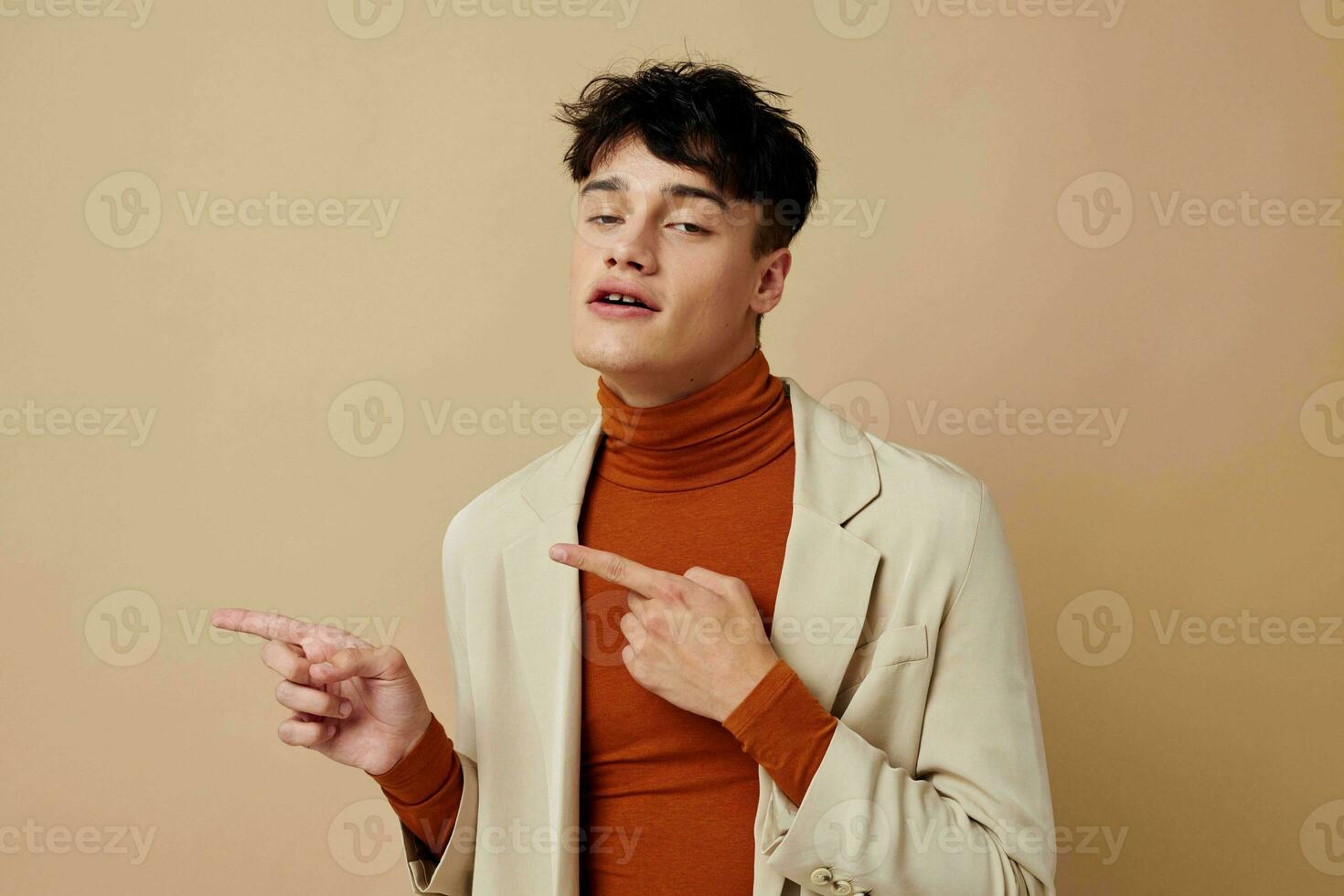 A young man posing with a phone in his hands in a jacket elegant style Lifestyle unaltered photo