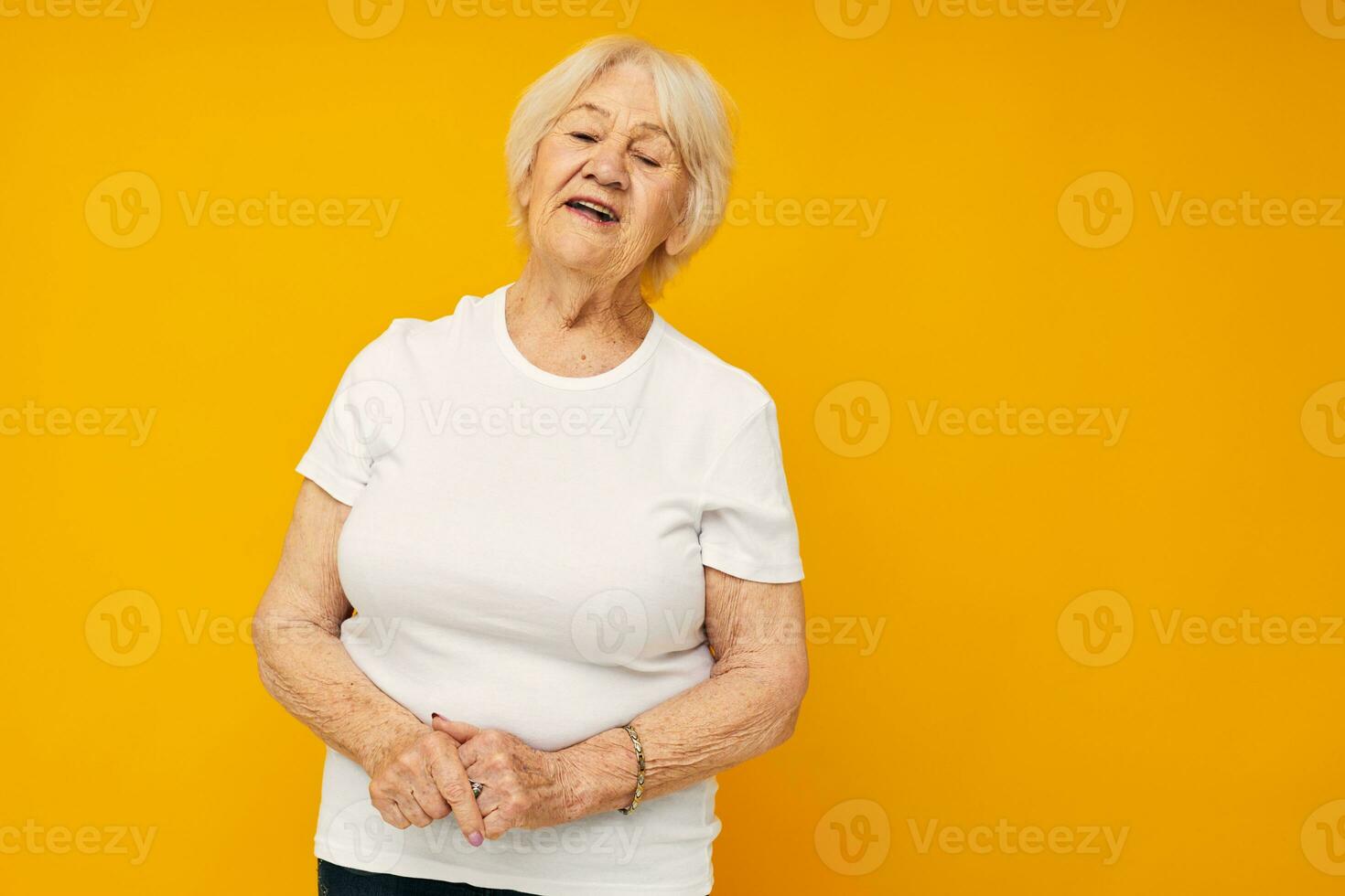 smiling elderly woman in casual t-shirt gestures with his hands cropped view photo