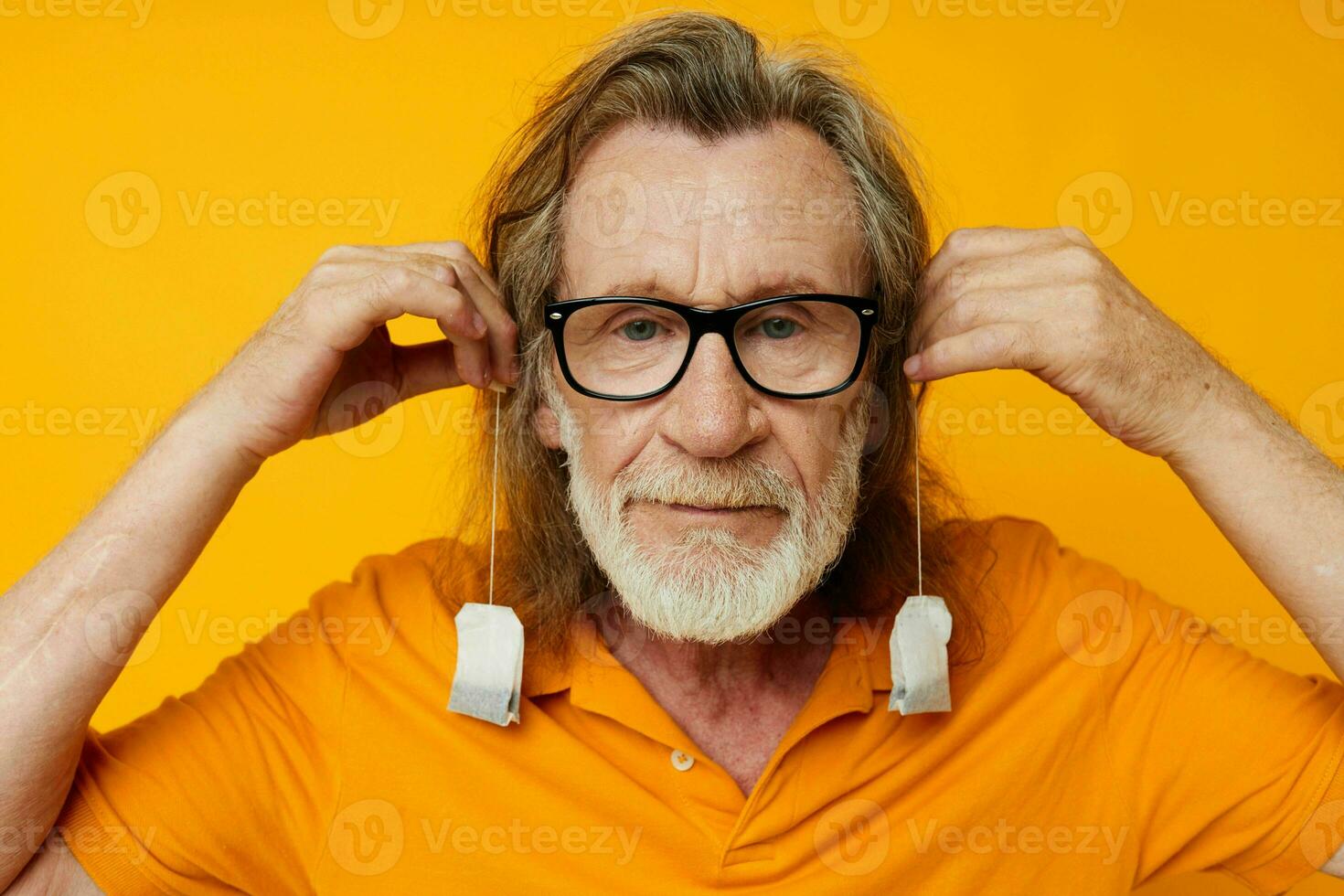 elderly man disposable tea bags near face yellow background photo