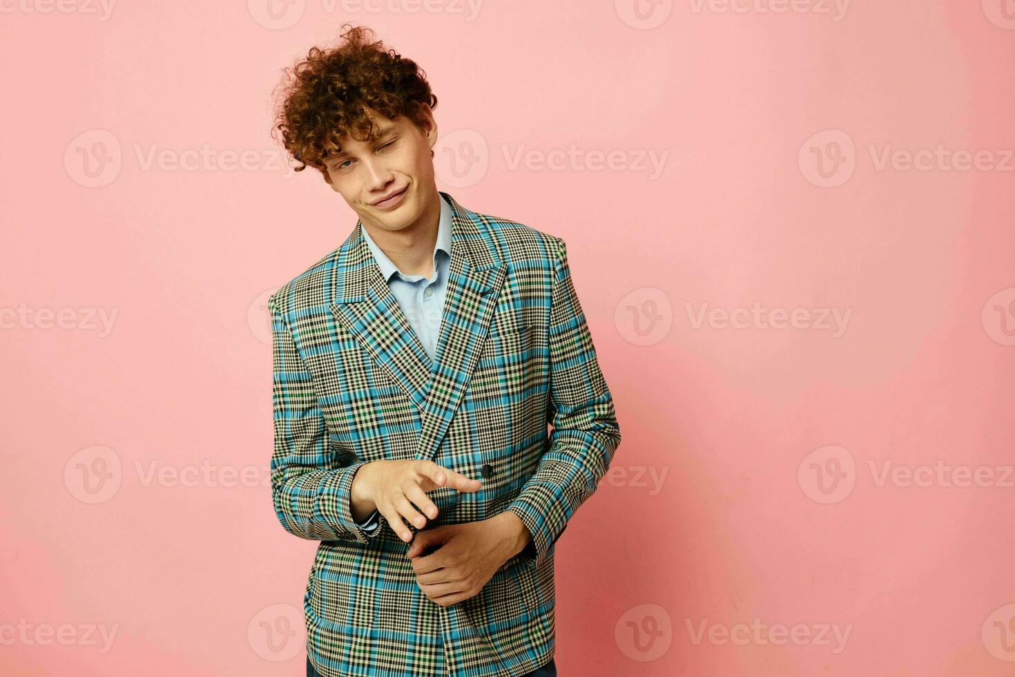 portrait of a young curly man checkered blazer elegant style posing fashion pink background unaltered photo