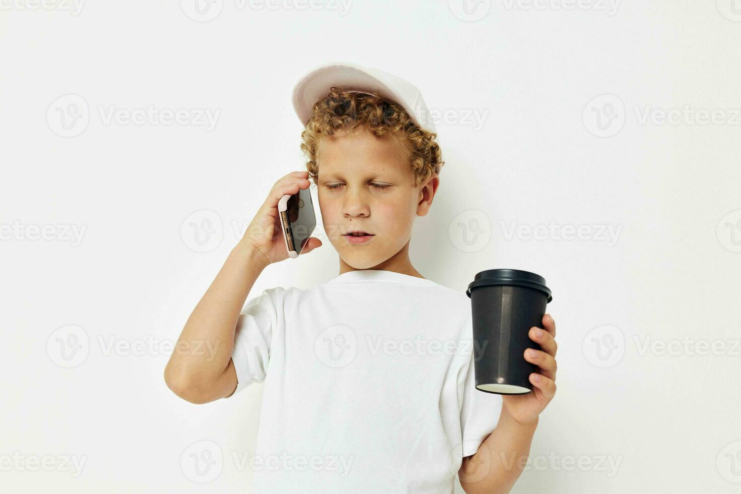 linda pequeño chico hablando en el teléfono con un negro vaso ligero antecedentes inalterado foto