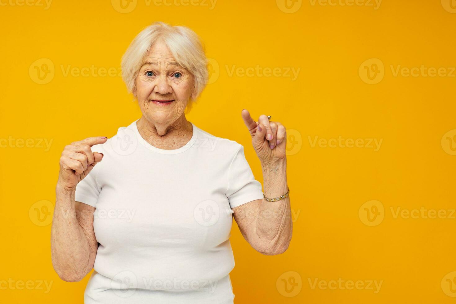 Portrait of an old friendly woman in casual t-shirt gestures with his hands close-up emotions photo
