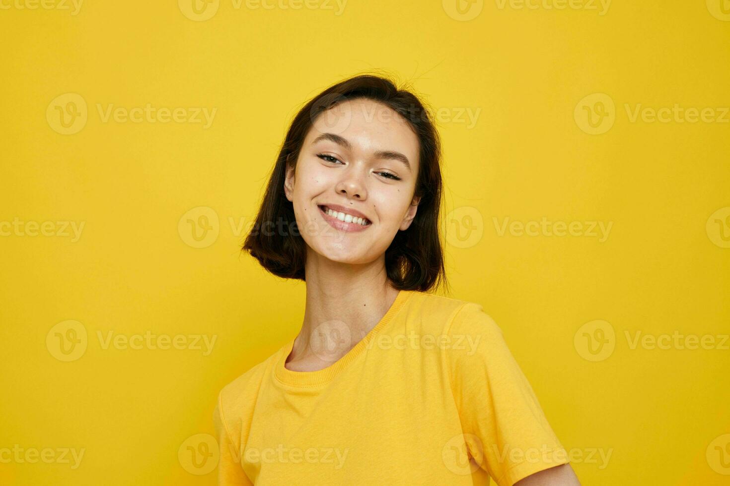 short haired brunette in yellow t-shirt posing fashion yellow background photo