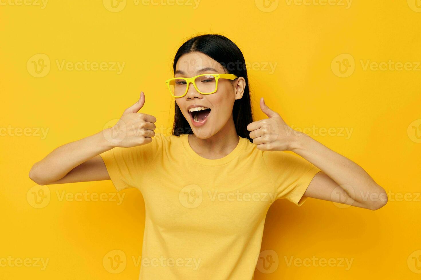 pretty brunette in glasses gesturing with hands copy-space yellow background unaltered photo