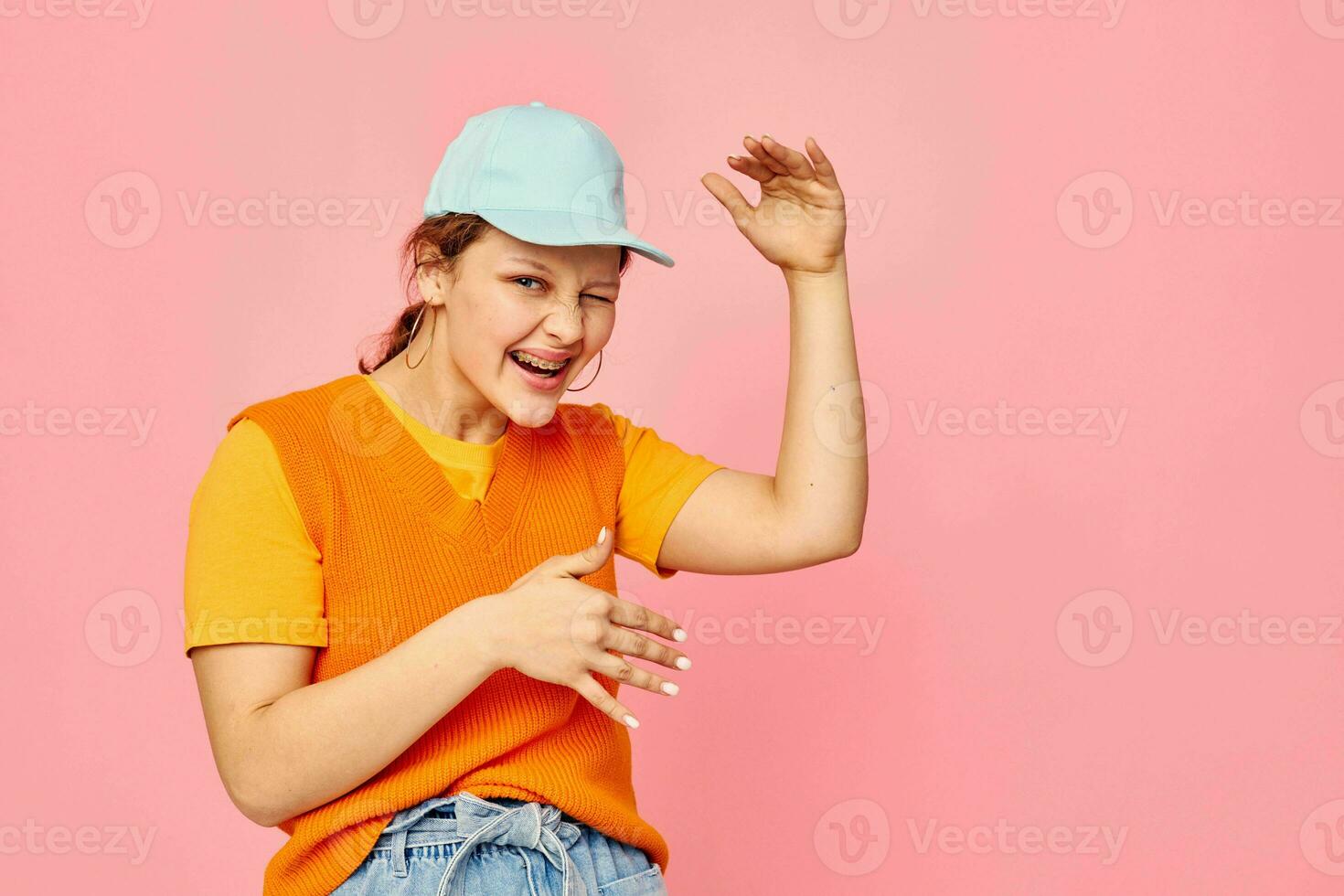 pretty girl in an orange sweater in blue caps hand gesture cropped view unaltered photo