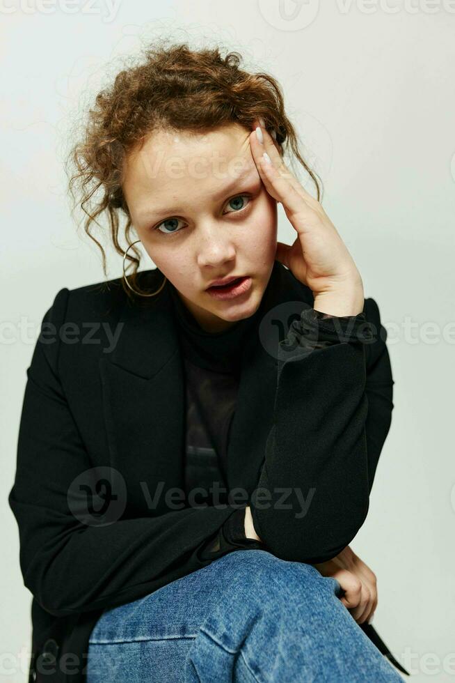 cheerful woman sitting on a chair in a black jacket fashion posing light background unaltered photo