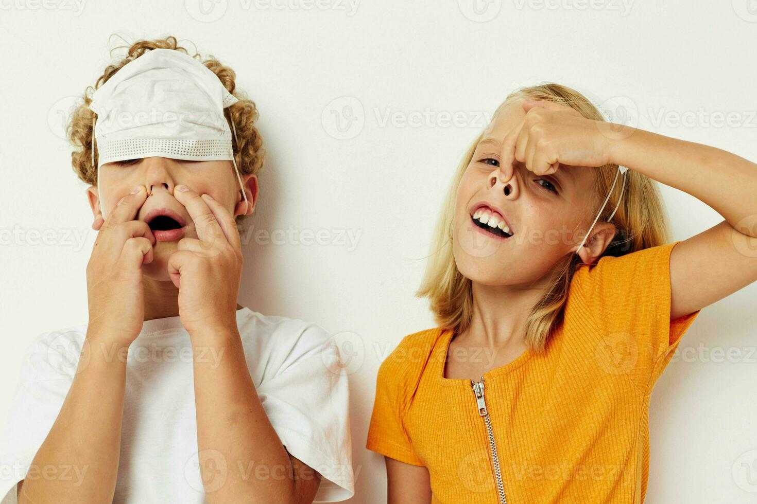 picture of positive boy and girl in a medical mask fun isolated background unaltered photo