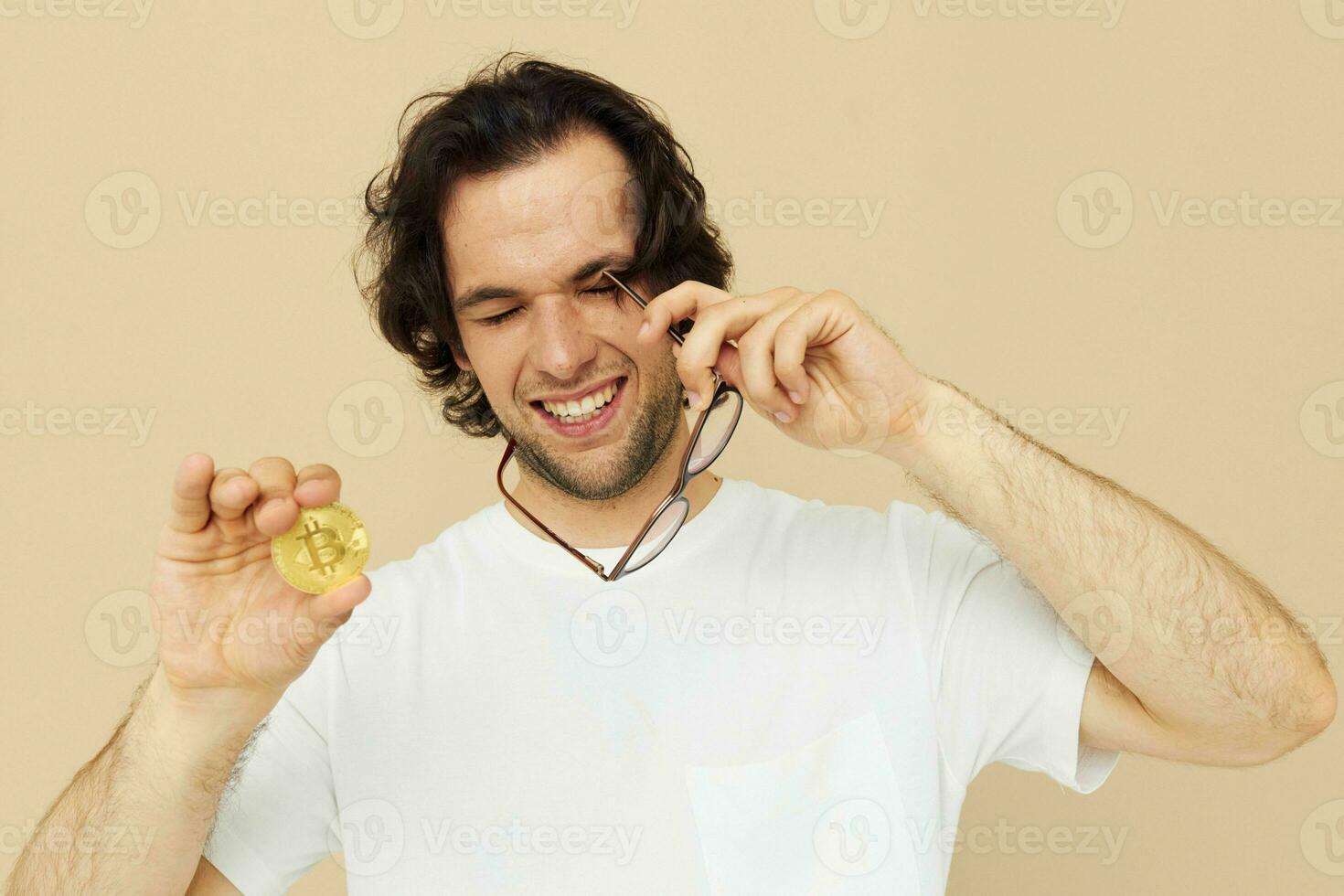 Cheerful man in a white T-shirt with Bitcoin cryptocurrency isolated background photo