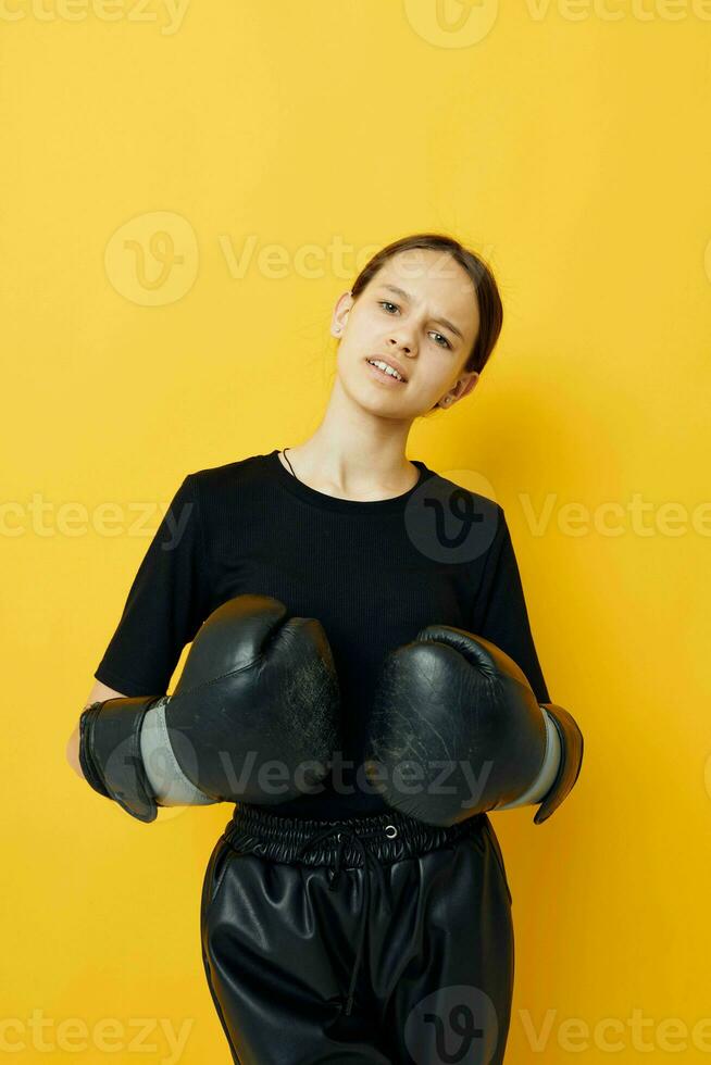 young woman black boxing gloves posing yellow background sport photo