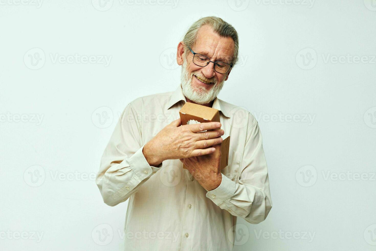 Old man with a small box in his hands in the studio alone photo