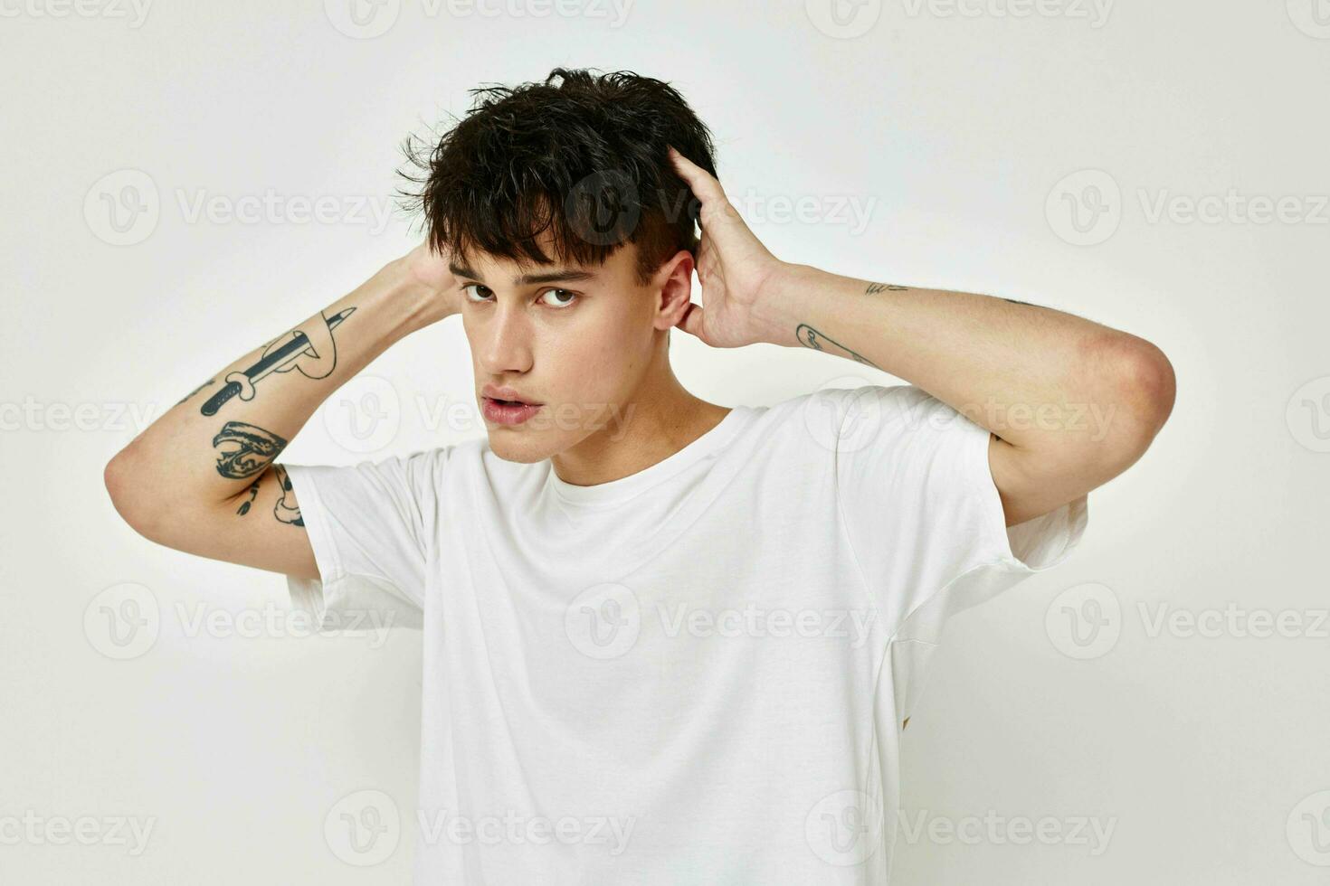 Man tattoo on hands in white t-shirt isolated background unaltered photo