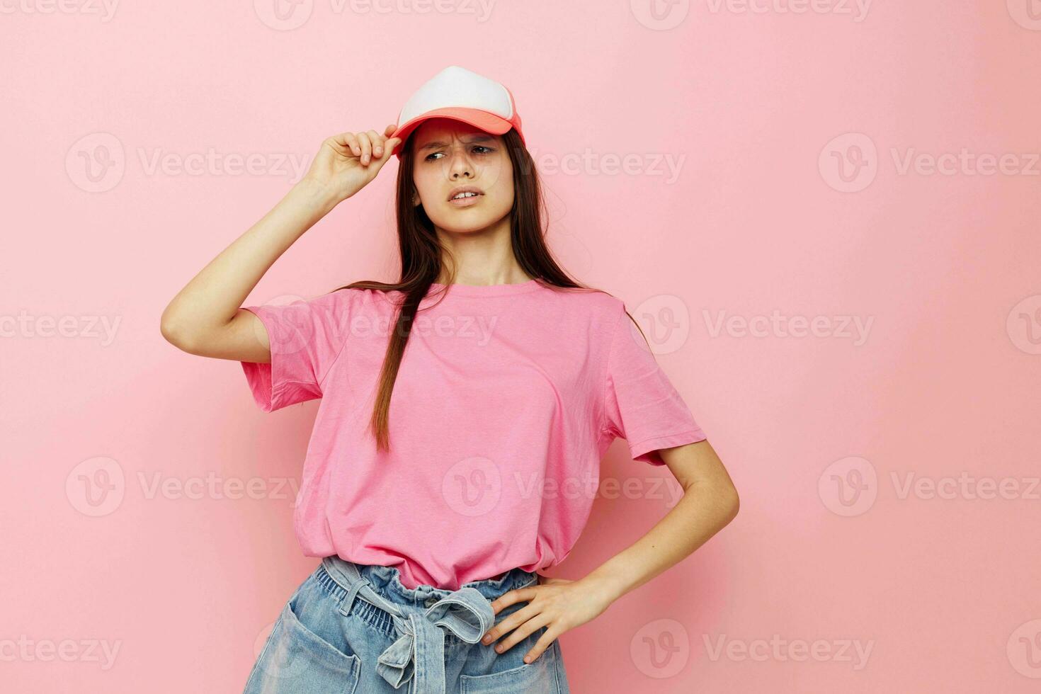 young girl in a pink t-shirt with a cap on her head casual wear photo